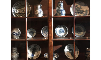 Détail sur les vitrines d'un vaisselier avec de la faïence