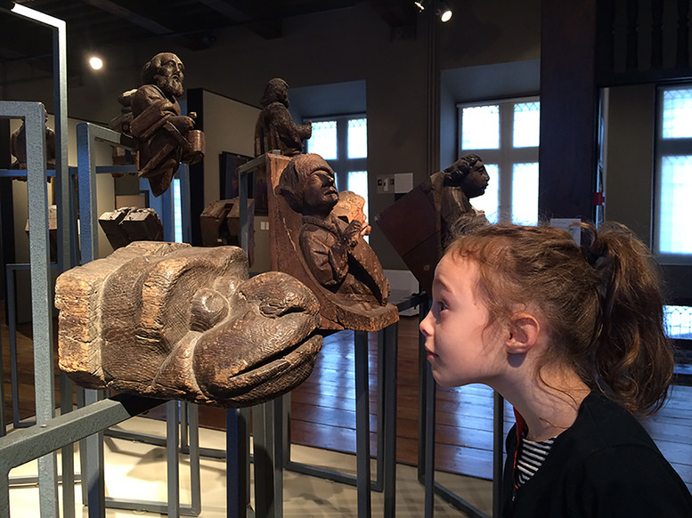 Enfant observant une tête sculptée de serpent